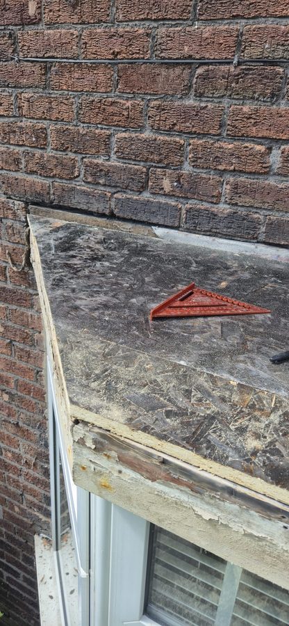 Perished covering on a bay window roof before renewal