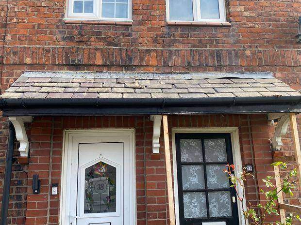 Original entrance canopy with worn slates, sagging line and a temporary timber prop holding the bracket