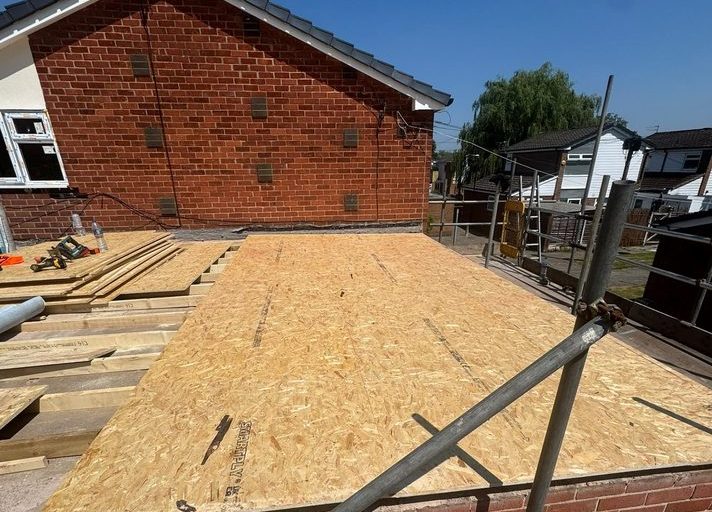 Newly decked flat roof with scaffold and handrail around the full perimeter before work starts