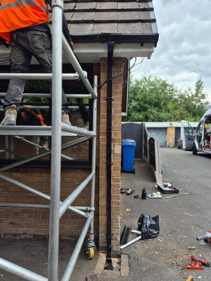 A mobile access tower set up against a house frontage with the footway kept open past the works