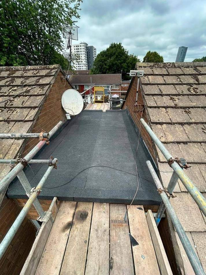 New torch-on felt covering laid to the same flat roof, dressed into the surrounding brickwork