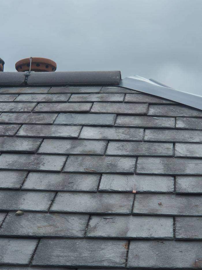 Closer view of the replacement slates and the slate vent, showing the new slates dressed in among the original covering
