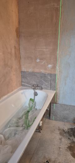 Plastered wall made good down to a newly fitted bath