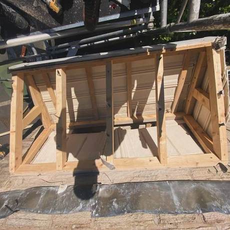New timber canopy framing built up over a doorway with the wall stripped back behind it