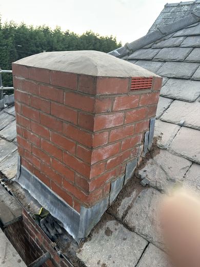 Chimney stack finished with a cast capping and a louvre vent to the side