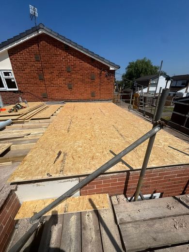 Newly decked flat roof with scaffold around the perimeter