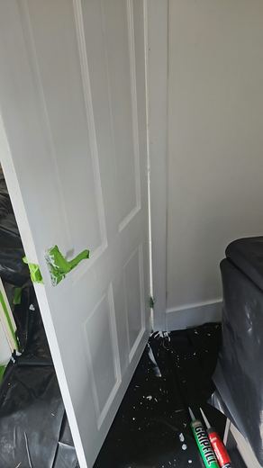 Internal door masked with tape and the floor sheeted for protection