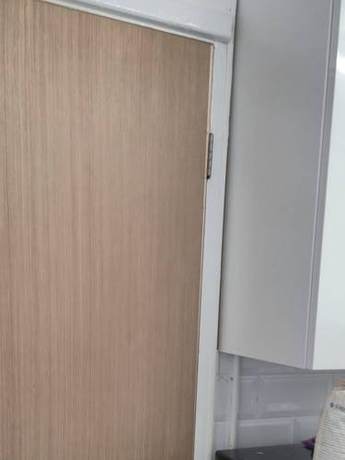 Completed internal doorset hung and closing against new linings in a kitchen doorway