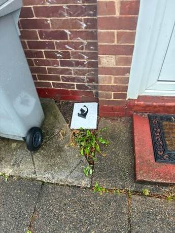 New downpipe discharging to a gully beside a doorstep on a brick elevation