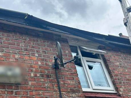 Eaves of a brick house with perished paintwork and an open joint between soffit and wall before renewal