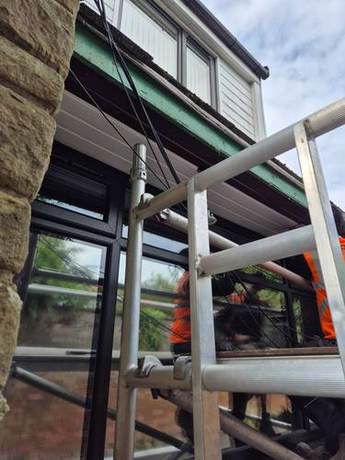 Operative working at the eaves of a house from a scaffold lift