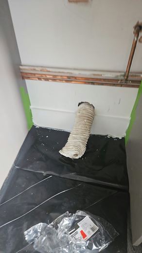 Flexible extract ducting run into a corner over a sheeted floor