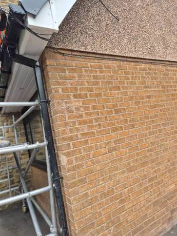 Completed white fascia and soffit running to a gable end with new black rainwater goods