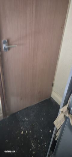 Bottom of a new fire door checked for gap over the floor finish
