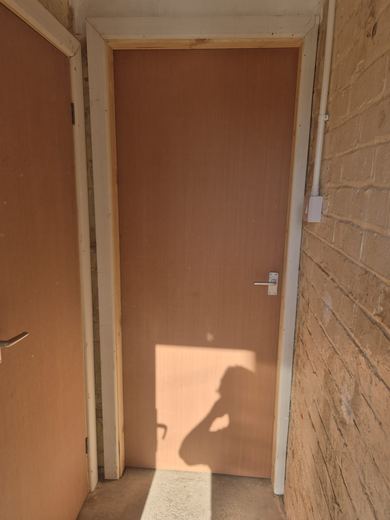 New fire door closing cleanly against the stop in its lining