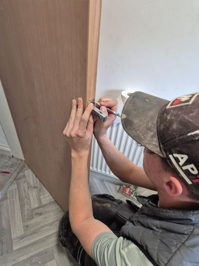 Operative fixing ironmongery to a new fire door leaf