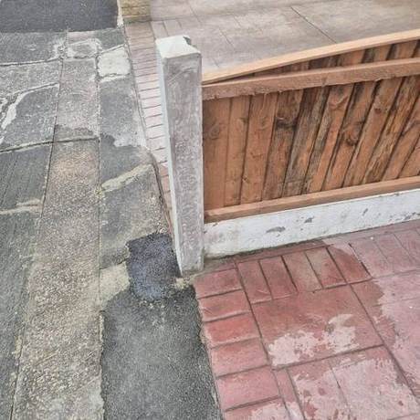 New concrete fence post and timber panel set into reinstated paving beside a driveway