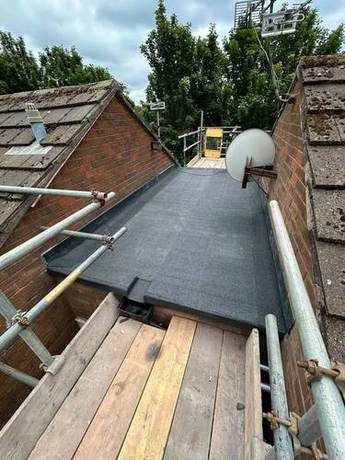 Completed torch-on felt flat roof with dressed upstands to the surrounding brickwork