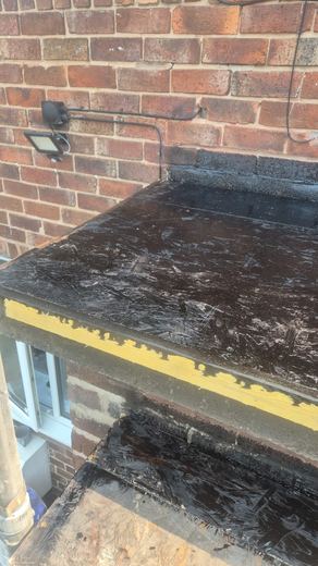 Perished flat roof covering at the edge trim above a window