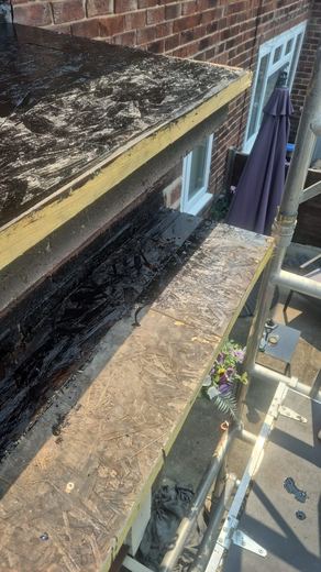 Flat roof perimeter with the old covering cut back to the deck
