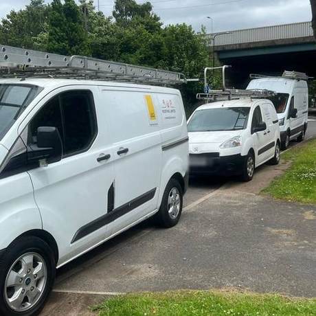 Three liveried R&D vans lined up on a verge while working on a contract