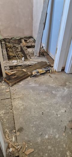 Floorboards lifted to expose the joists below