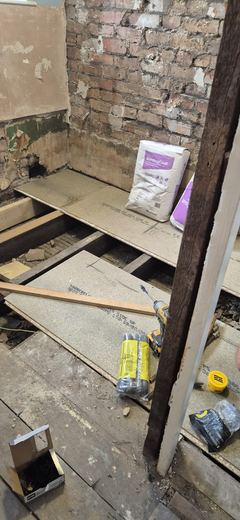 Floor taken out back to the joists with materials staged on the boards