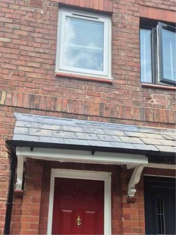 Front elevation of a brick house with the roofline, eaves and rainwater goods completed