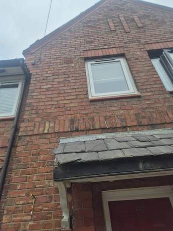Gable end of a brick house with the roof verge and eaves made good