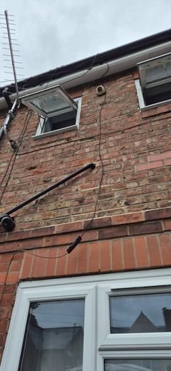 Gutter, downpipe and stack run down a gable elevation