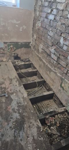 Floor opened up with the joists exposed for inspection