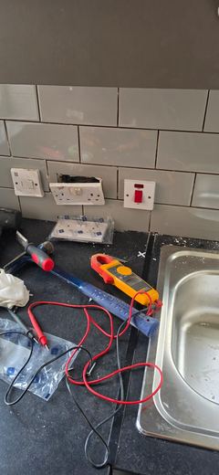 Test meter and leads on a kitchen worktop during electrical testing