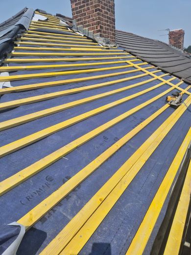 Breather membrane laid and new treated battens fixed across the slope