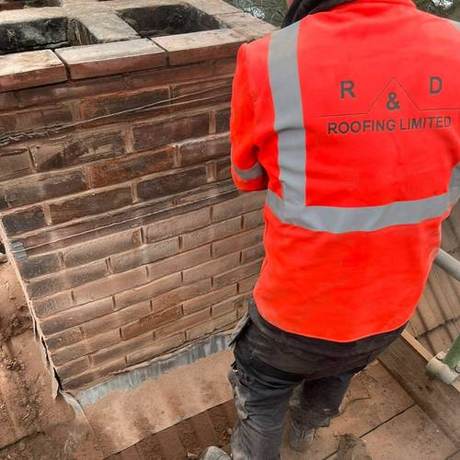 Operative in R&D Roofing hi-vis dressing lead into a brick parapet from the scaffold