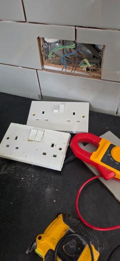Socket faceplates and test meter during electrical testing