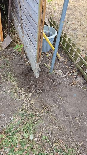 New concrete post set into the ground beside the old boundary