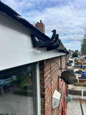 New white soffit and fascia with a black gutter, hopper and downpipe fitted at a roof junction