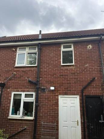 Rear elevation of a brick house with the roofline and rainwater goods completed
