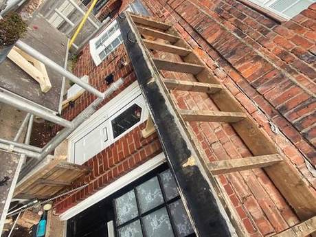 Roof ladders laid up a slate slope with the eaves and gutter line below