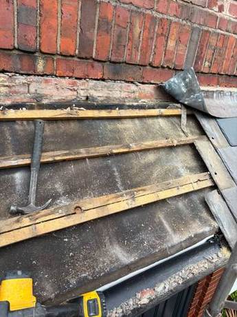 Roof slope stripped back to the battens and perished torching, with the lead flashing turned back