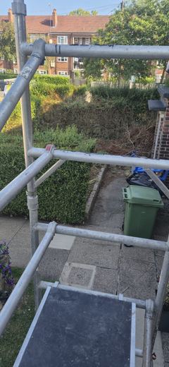 Scaffold erected in a rear garden to reach the roof