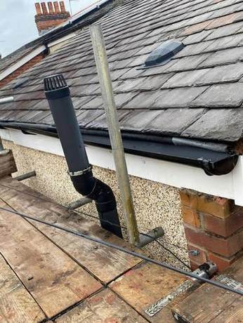 New soil vent pipe terminal weathered into a slate roof with a new gutter along the eaves
