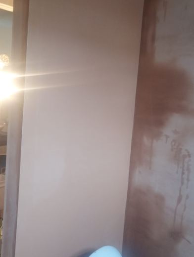 Finished skim coat catching the light across a wall