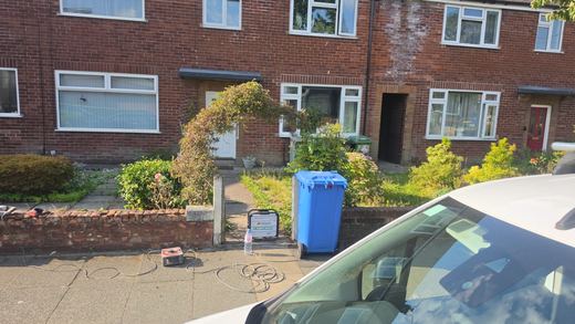 Compressor and hoses set out on the footway in front of the property being worked on