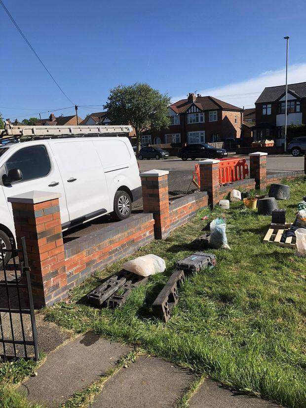 The rebuilt boundary wall with new brick piers and precast copings running along the street