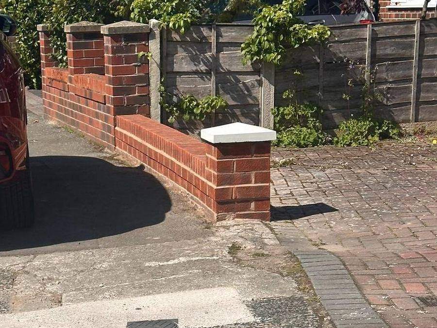 Rebuilt dwarf boundary wall with a new brick pier and precast coping at a driveway entrance