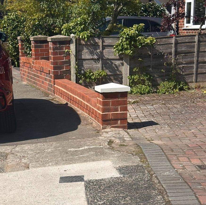 The rebuilt boundary wall with a new pier and coping finished along the frontage